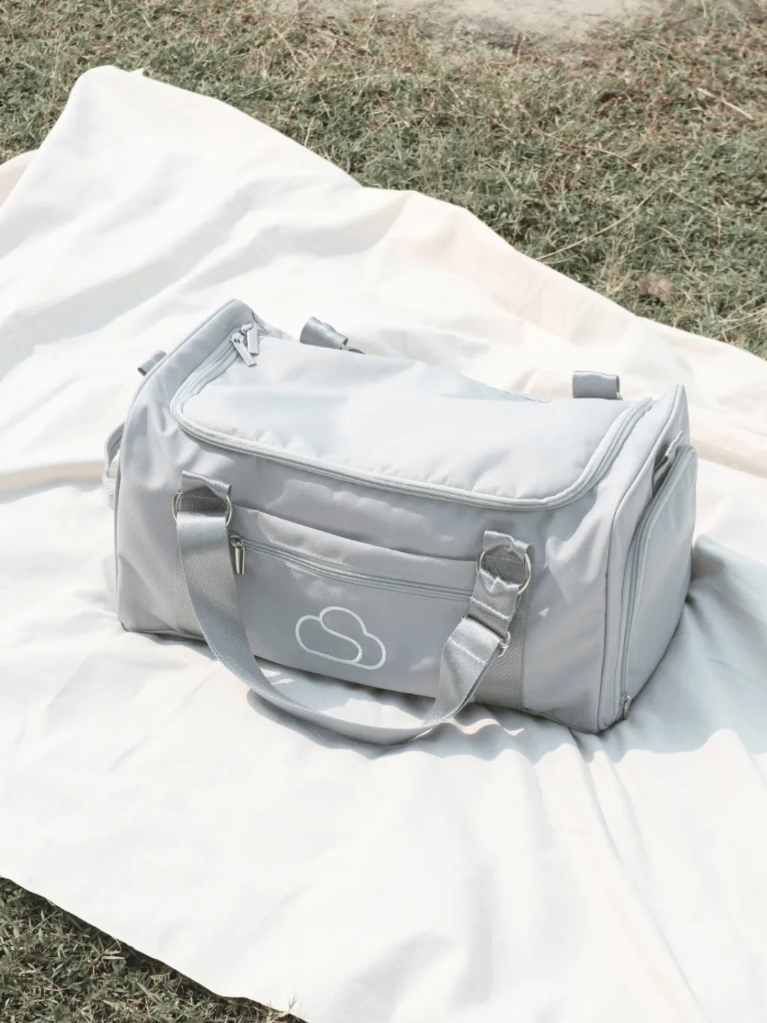 Skylaris Wanderer Duffel in Stone on a white picnic mat outdoors